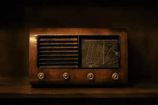 a brown radio sitting on top of a wooden shelf