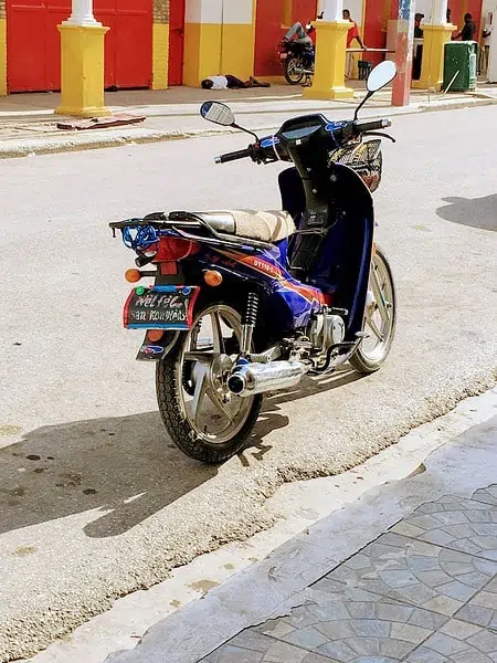 black and red motorcycle parked on gray concrete road during daytime