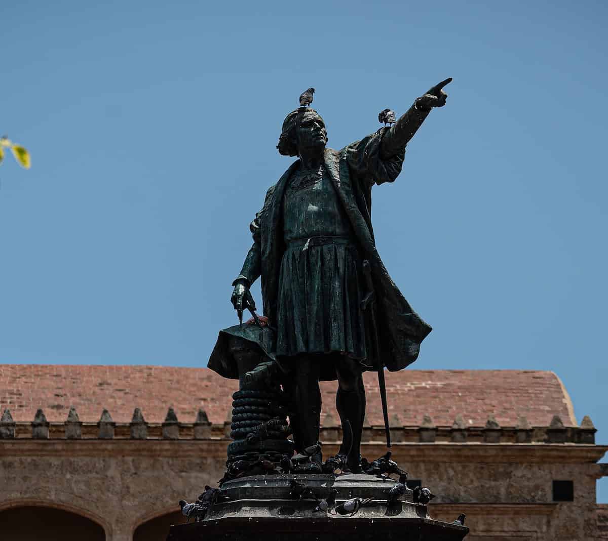 black statue of man holding yellow umbrella